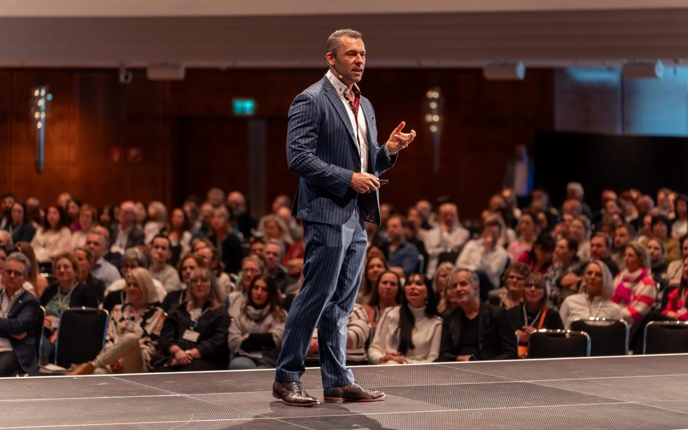 Dr. Stefan Helka spricht vor Publikum auf einer großen Bühne
